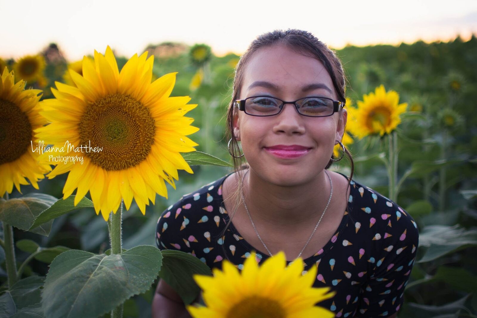 Close-up of a smiling daughter surrounded by sunflowers