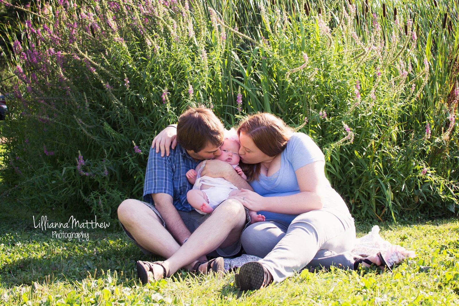 Full family huddle embracing together in a flower field