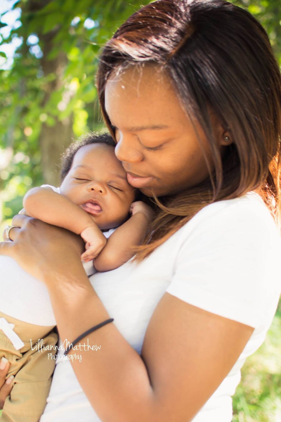 Mother tenderly cradling her sleeping newborn in a close-up portrait