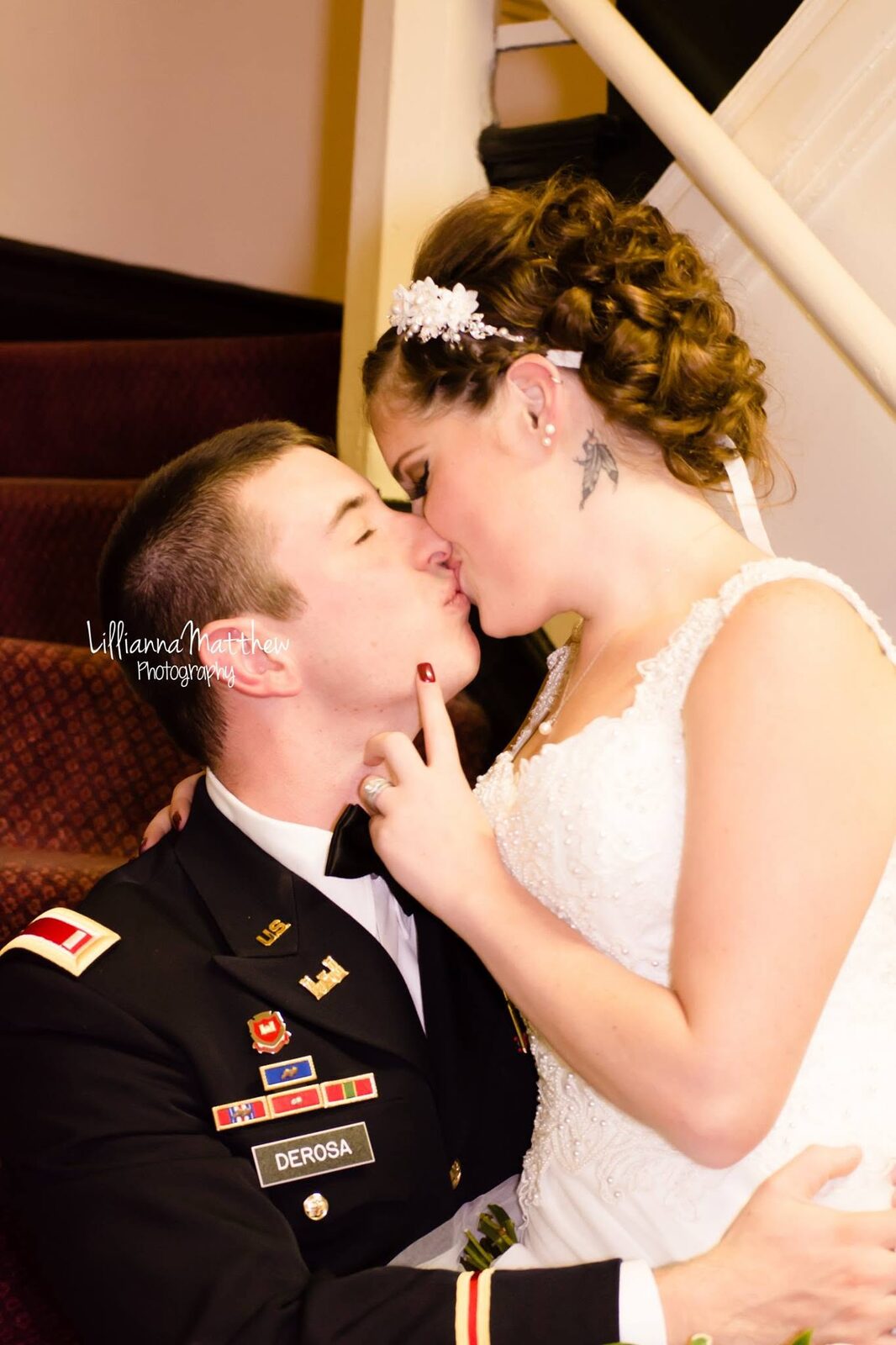 Bride and groom in military uniform sharing a kiss on a staircase
