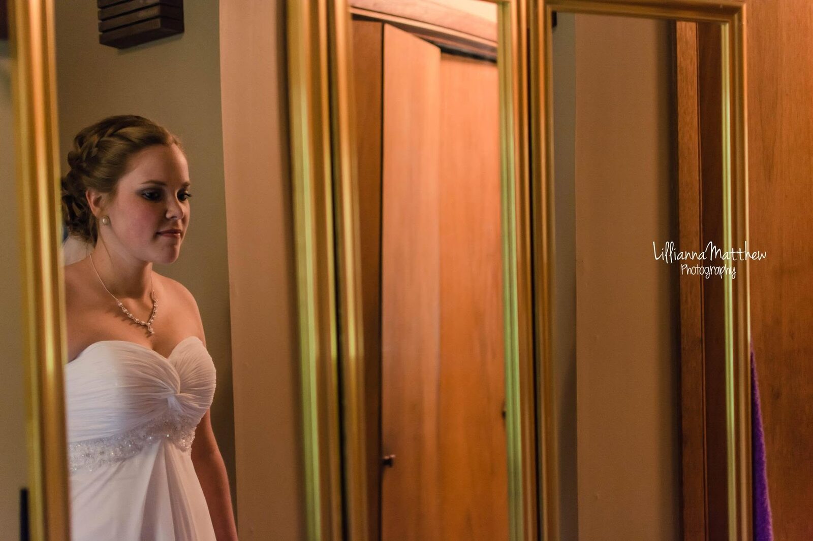 Bride seen in a mirror reflection while getting ready