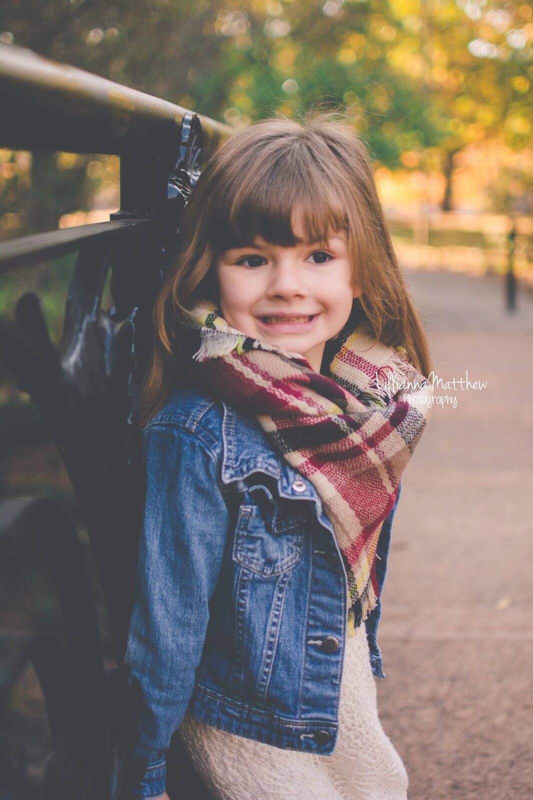 Close-up smiling portrait of a girl in a denim jacket and plaid scarf
