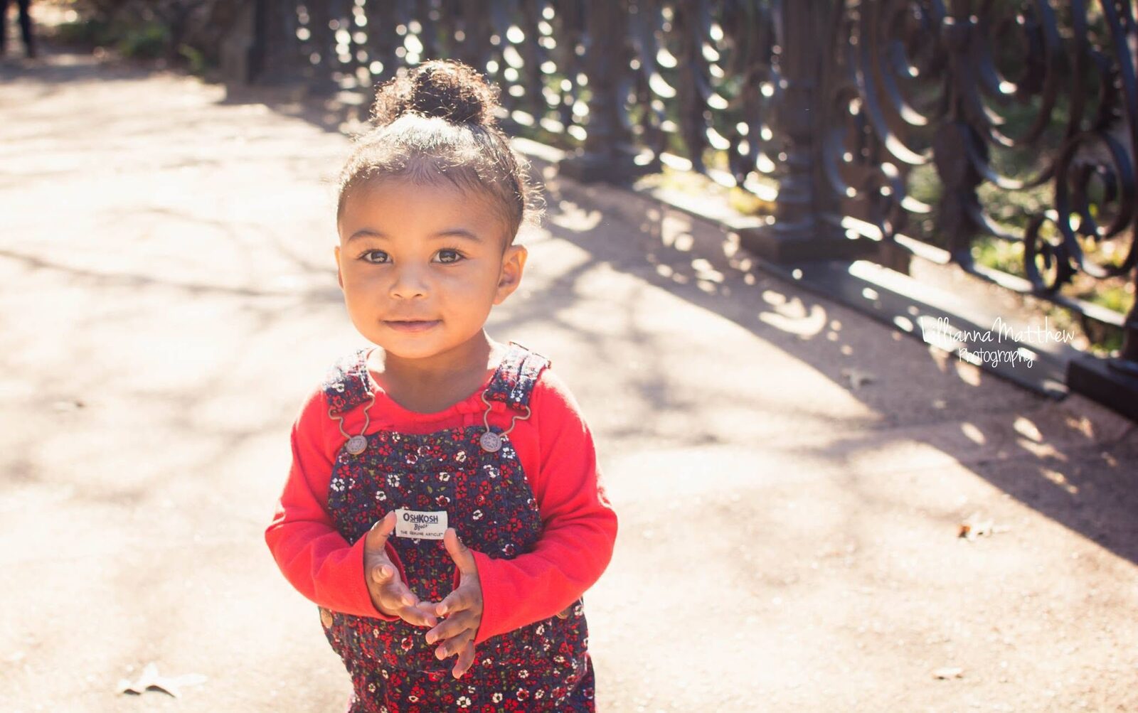Solo portrait of a young girl with her hair in a bun, holding an acorn