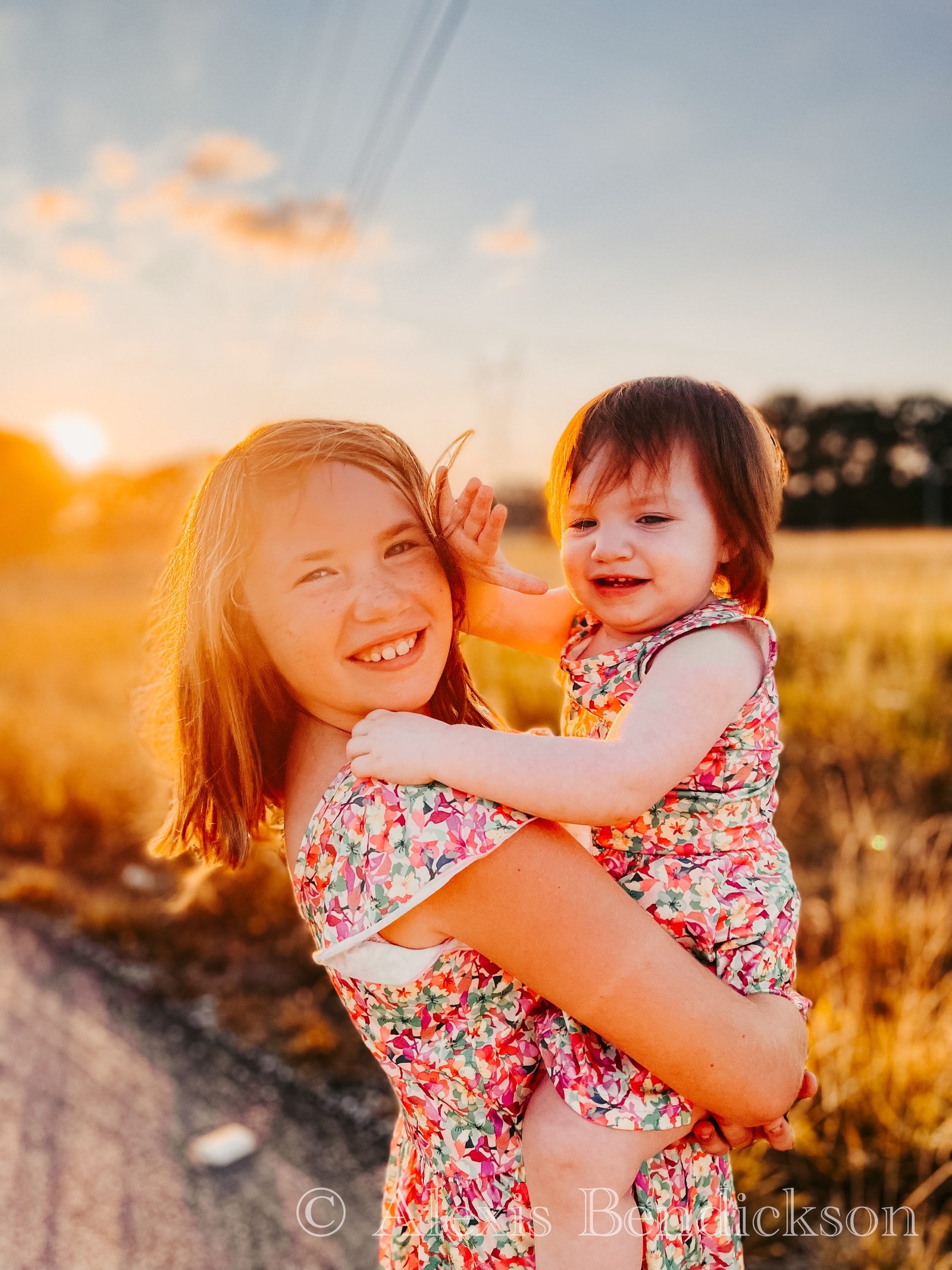 Arianna carrying Emme at sunset, both smiling