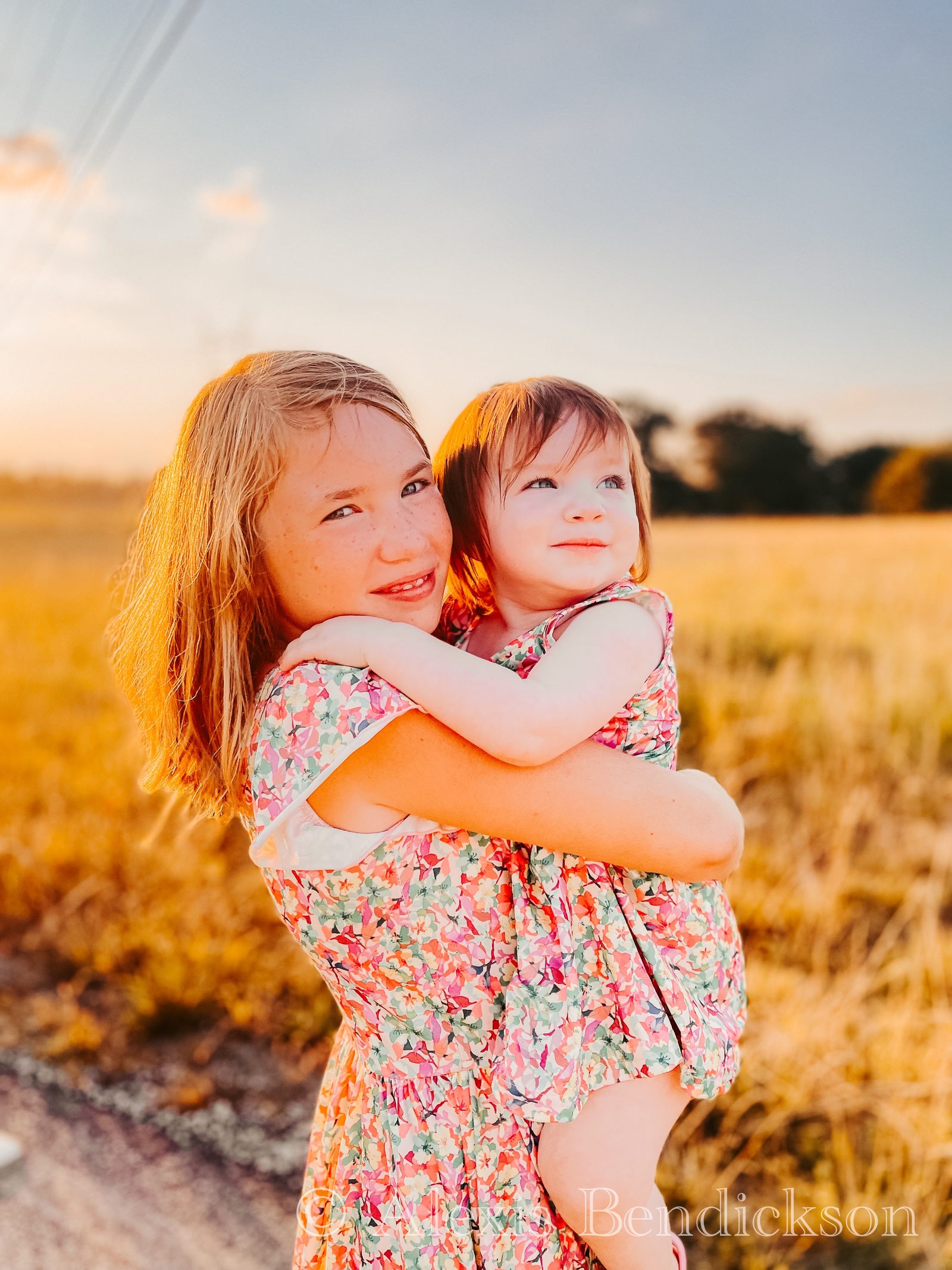 Arianna holding Emme in golden light at sunset
