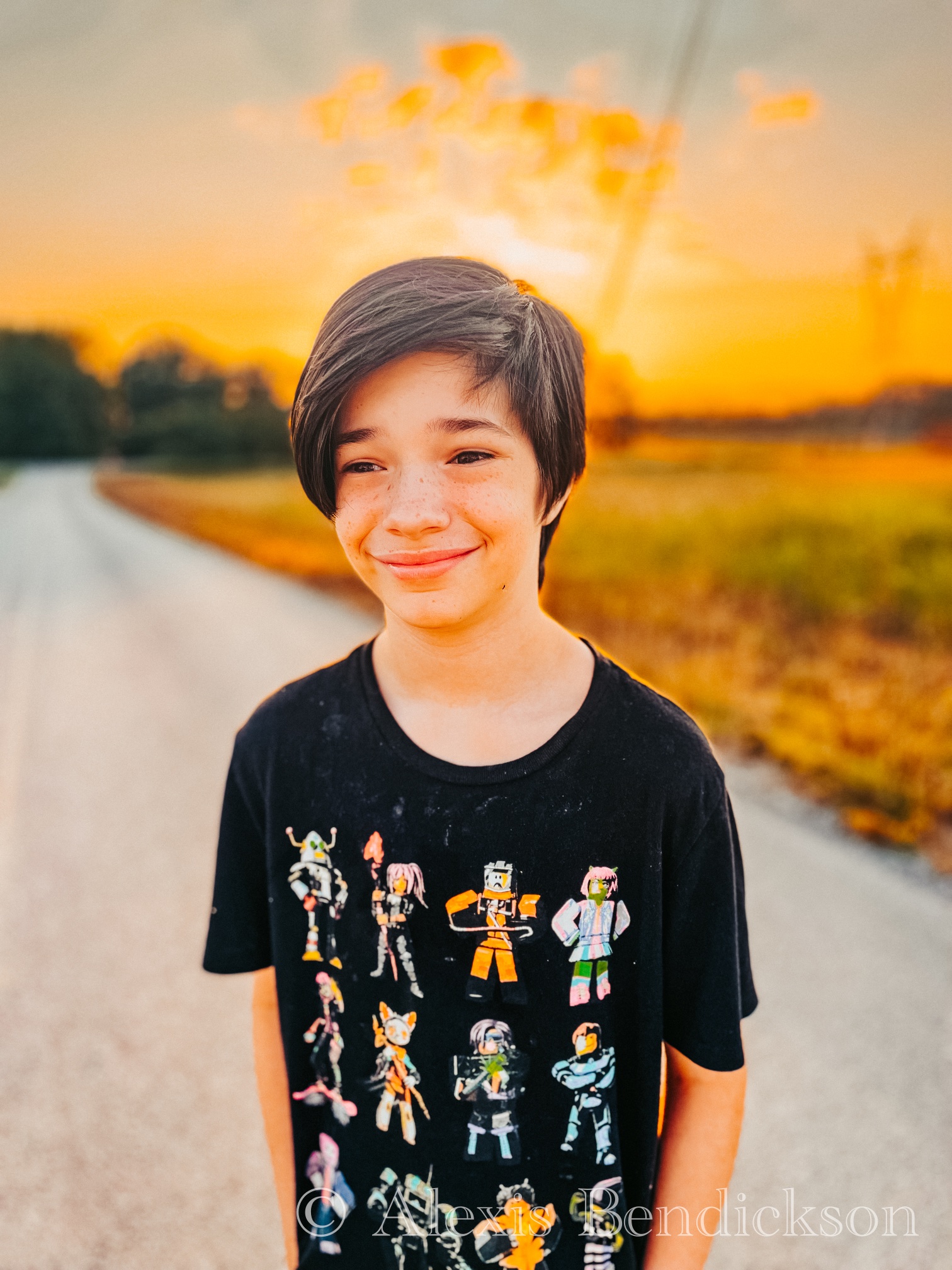 Golden hour portrait of Noah in a Roblox t-shirt smiling on a country road