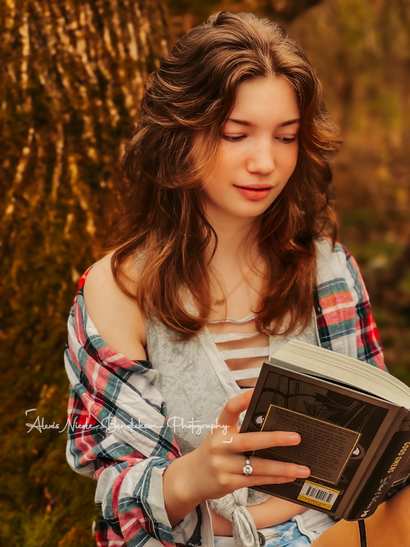 A young woman reading a book in the woods