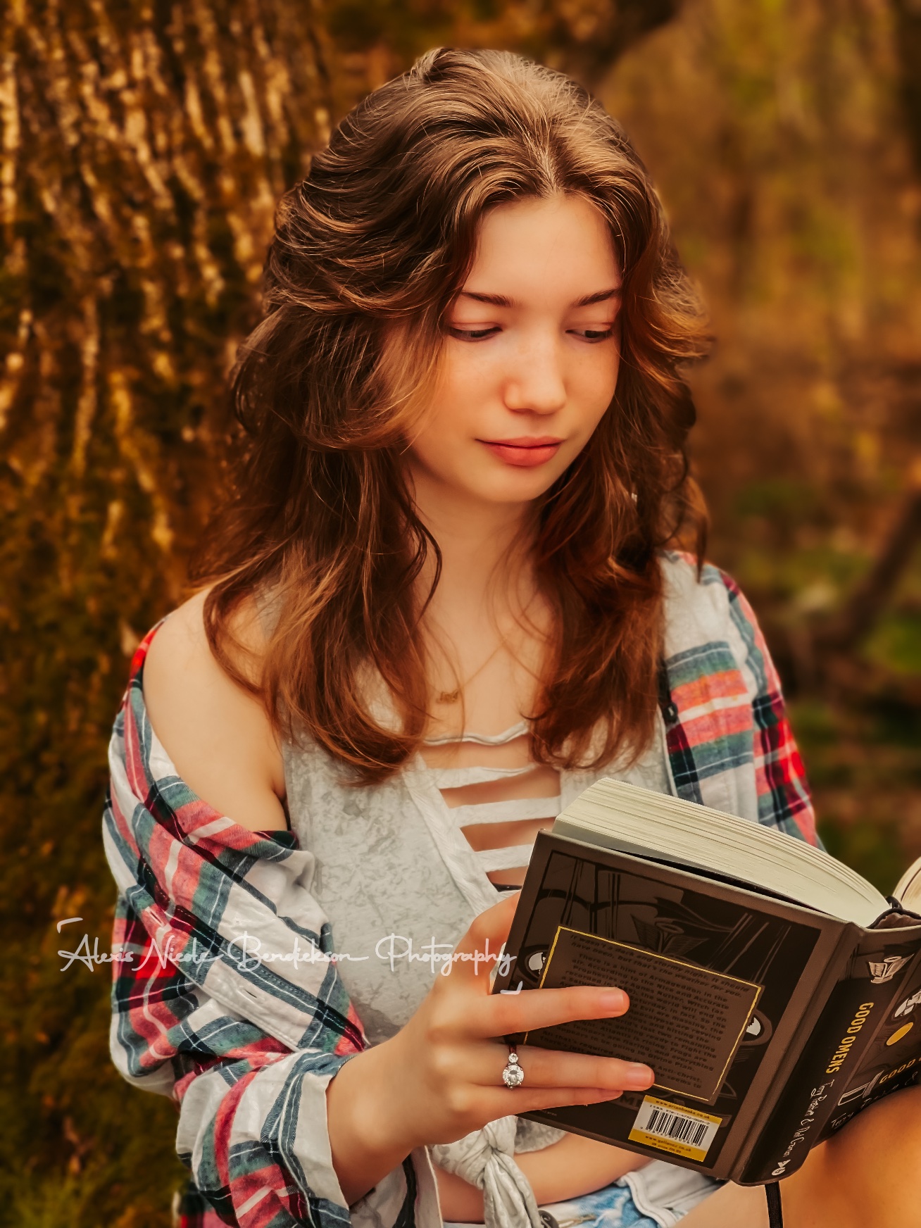 Close portrait of a young woman reading in the woods