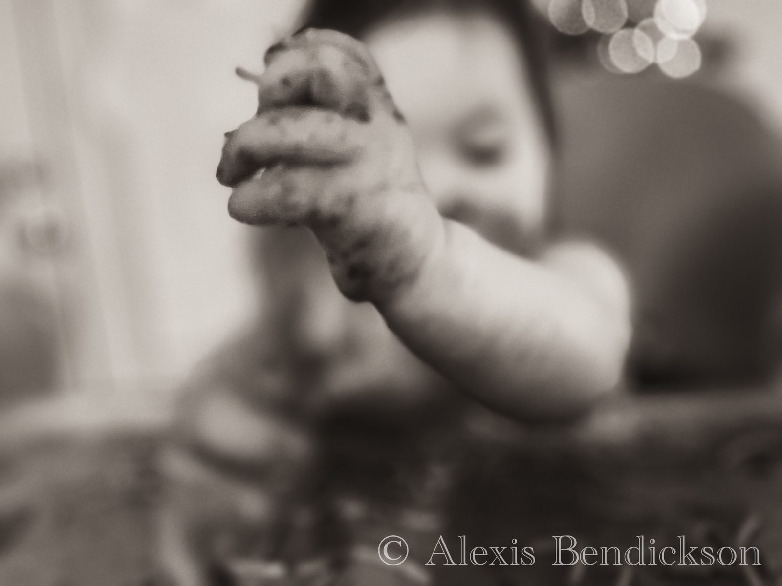 Baby Emme's spaghetti-covered hand reaching toward the camera, black and white