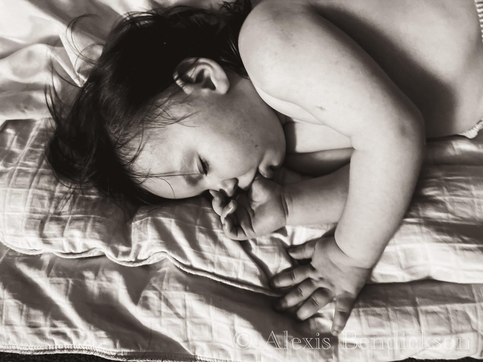 Baby Emme sleeping on a pillow, black and white