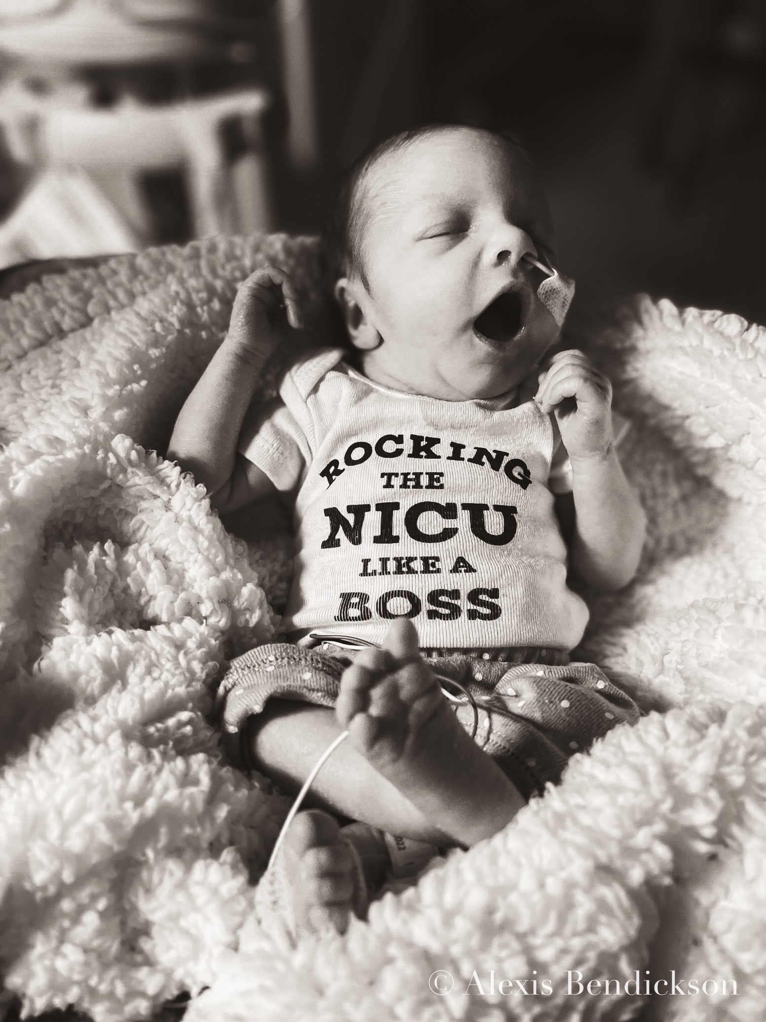 Emme yawning in a 'rocking the NICU like a boss' onesie, black and white, February 2022