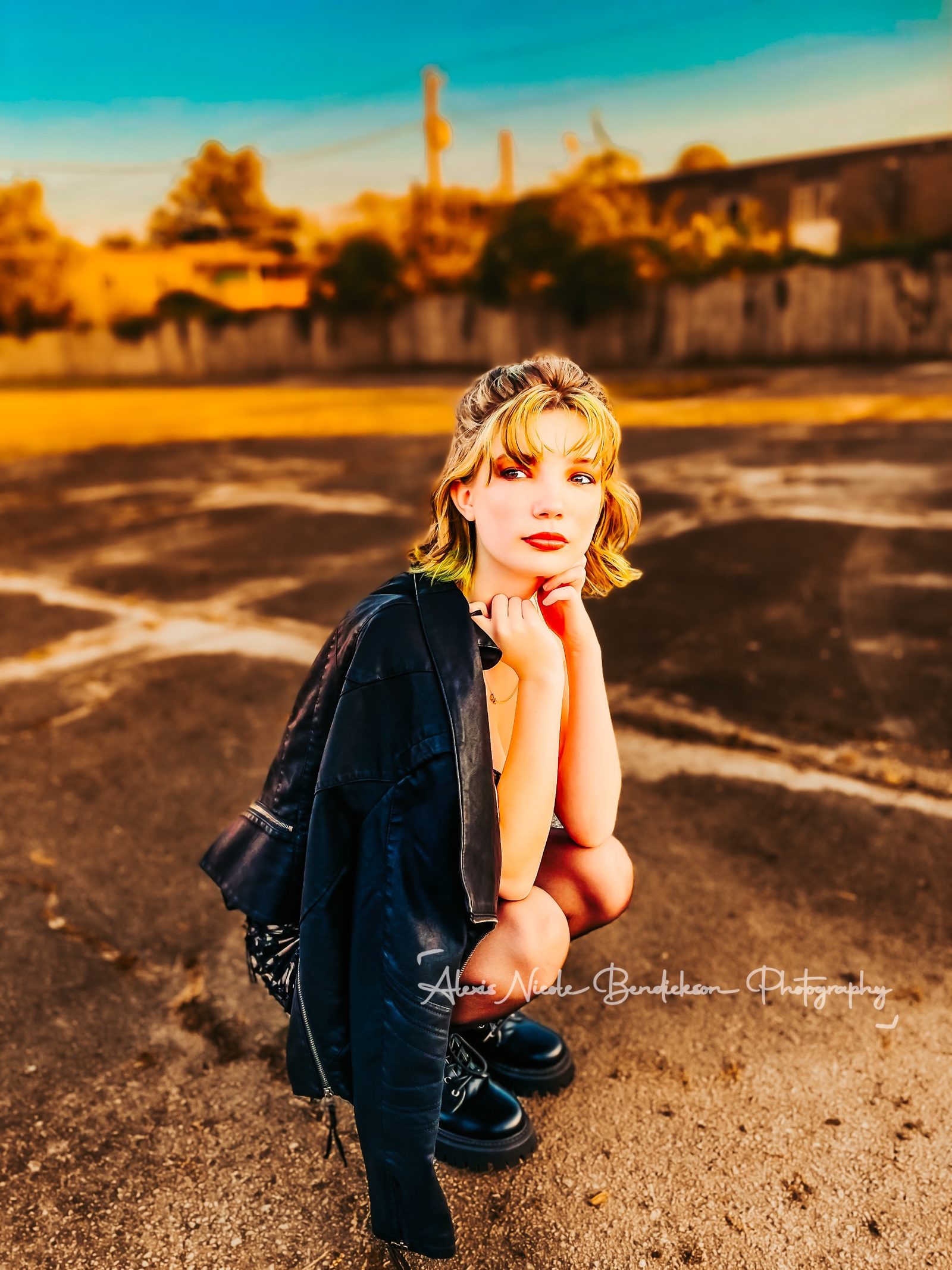 Lillia crouching in a parking lot, chin resting on her hands
