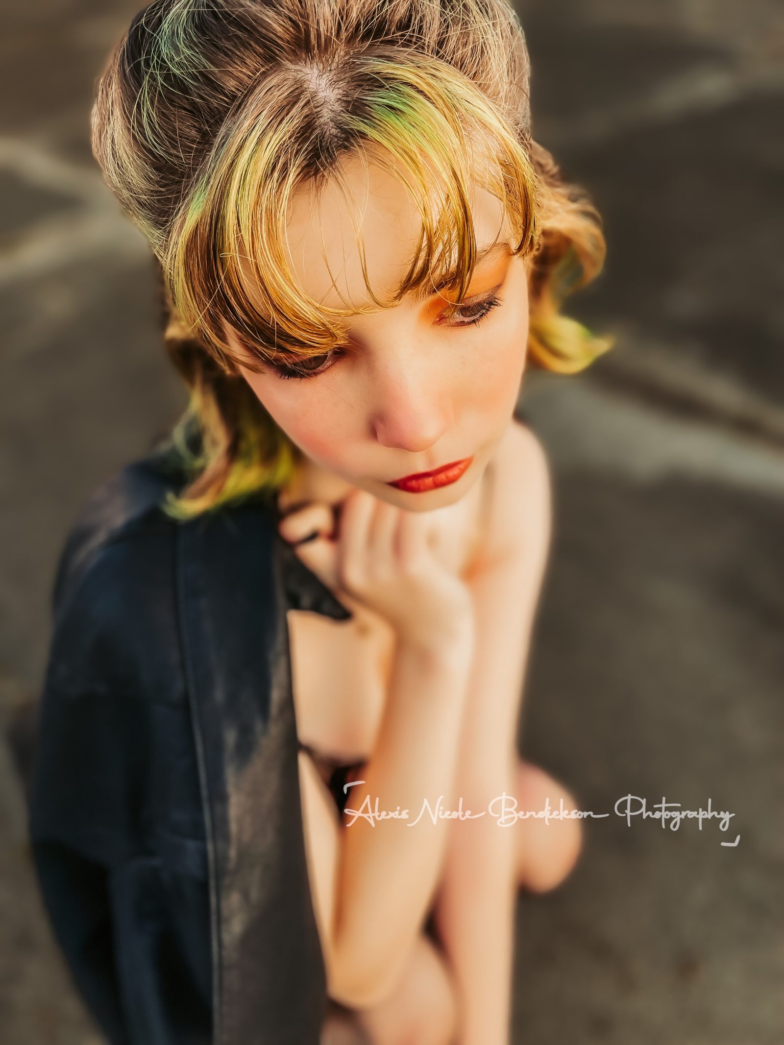 Close portrait of Lillia drinking from a tall cup against a white brick wall